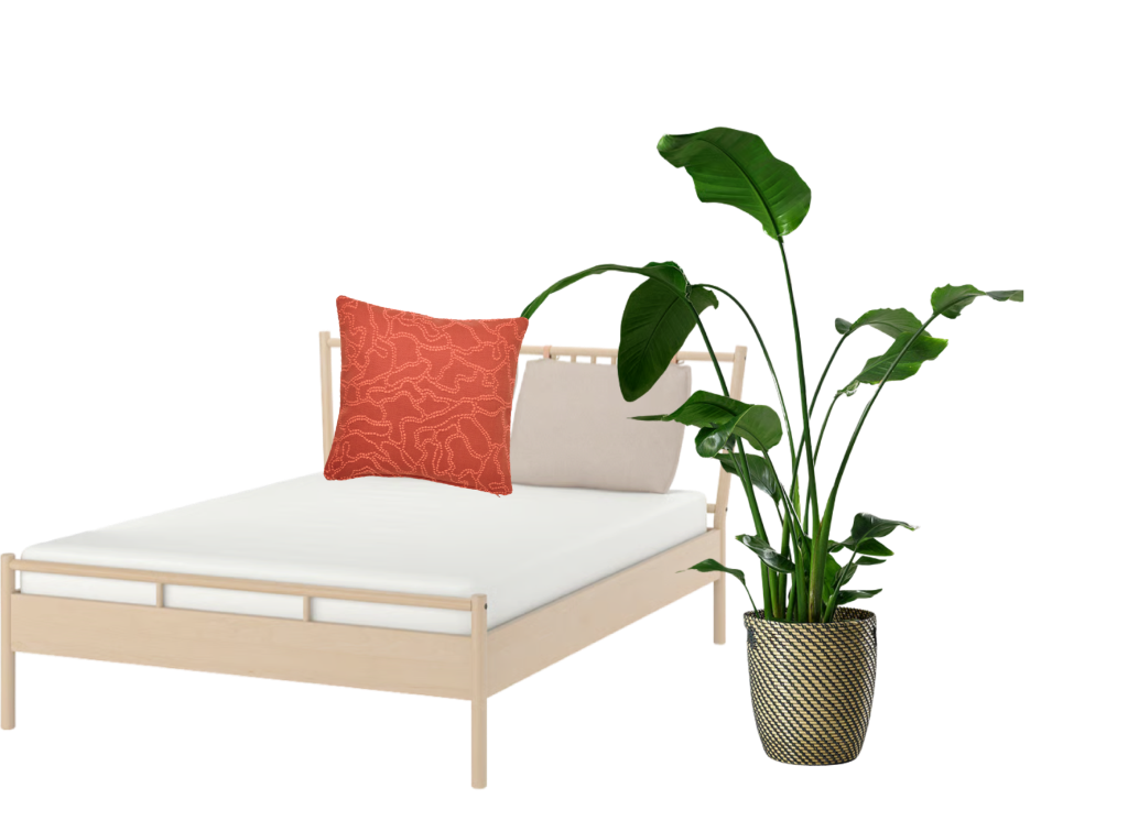 IKEA daybed with white mattress, coral patterned cushion, and decorative potted plant